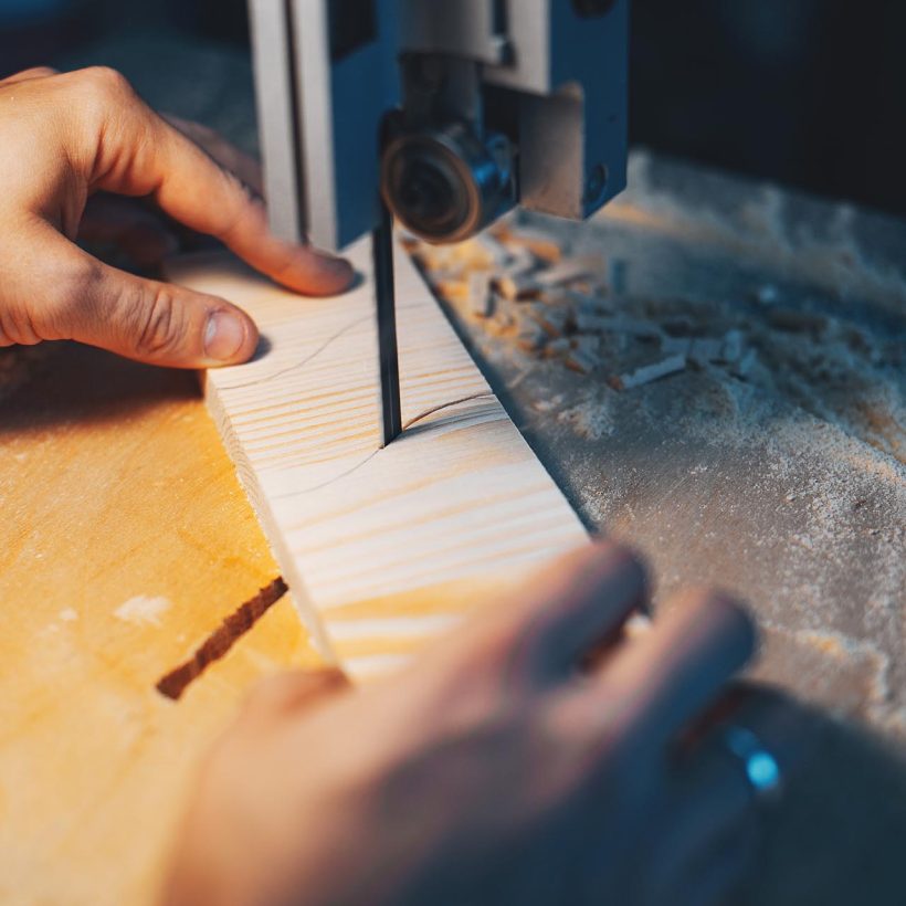 A man carves a tree. The carpenter works in a studio. An engineer provides a tree shape